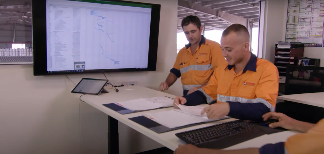 Two Northern Transportables staff reviewing a project schedule in the office